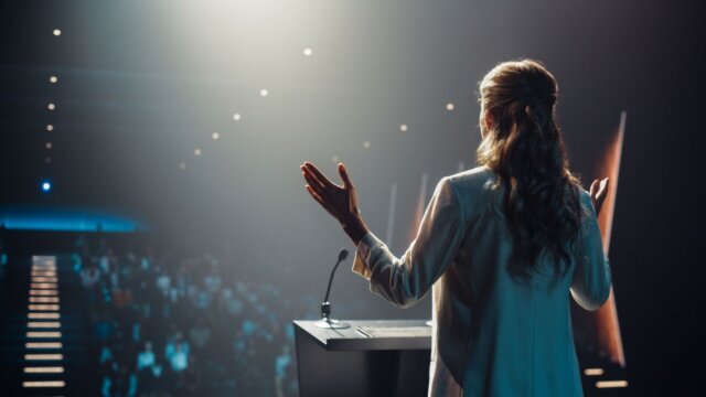 Female speaking to a crowd.
