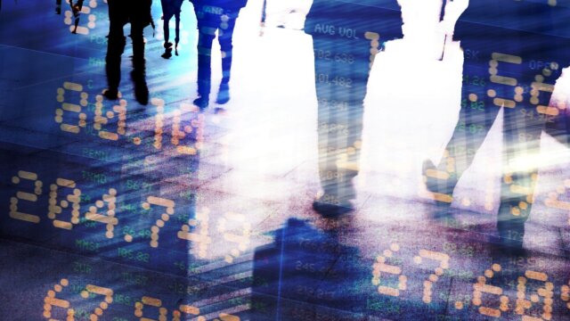 Abstract image of traders in financial district with trading screen data, light reflections and blurred movement.