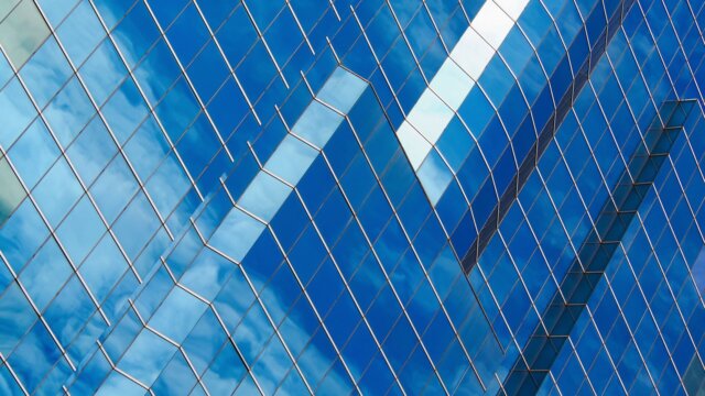 Glass facade reflecting blue sky