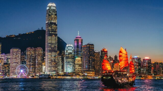 Junkboat on water in Hong Kong Harbor at night.