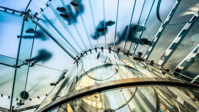 People walking on transparent staircase with camera looking from below.