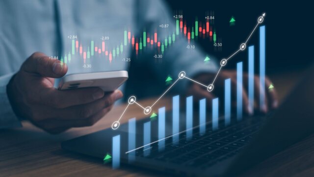 Person at laptop with investment portfolio displayed.