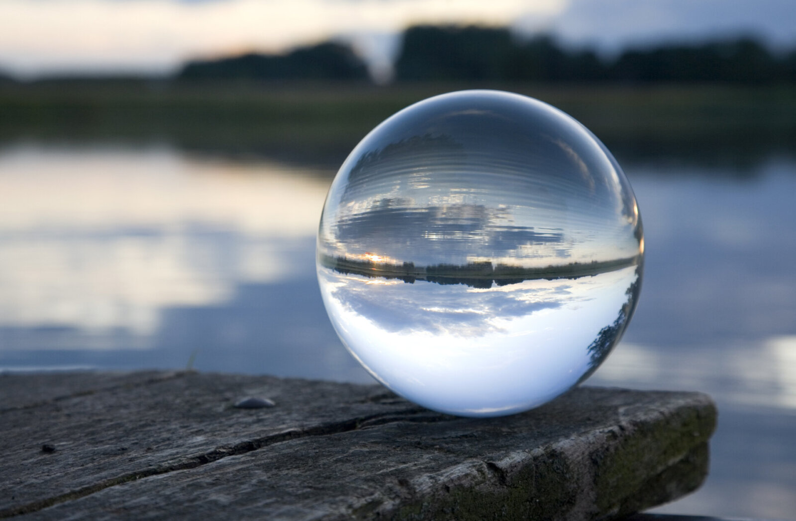 Glass ball on a footbridge at the foreground of a photo where everything else is blurry.